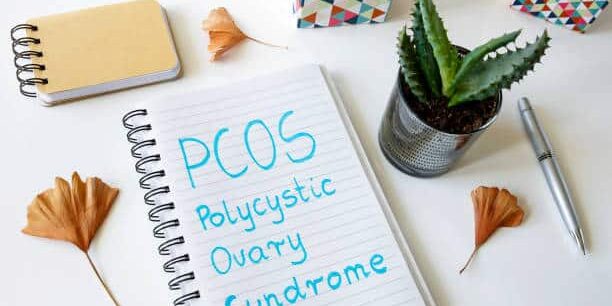 PCOS Polycystic ovary syndrome written in a notebook on white table PCOS, Polycystic Ovary Syndrome, symptoms, causes, treatment, hormonal imbalance, irregular periods, fertility, lifestyle changes